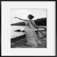 c Fotografija sumraka sažetka: Žena u tekućoj haljini na plaži, pokazuje