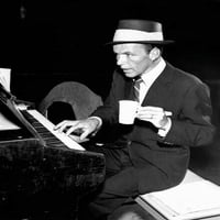 Frank Sinatra u odijelu i šeširu sjedi na piano holding kup postera za kafu